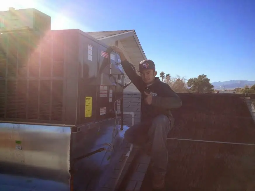 HVAC technician performing Air Duct Cleaning on a rooftop unit in Auburn